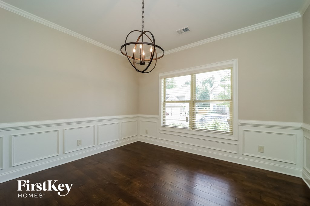 an empty dining room with wood floors and a window
