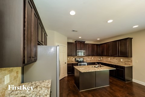 a kitchen with dark wood cabinets and granite counter tops and stainless steel appliances