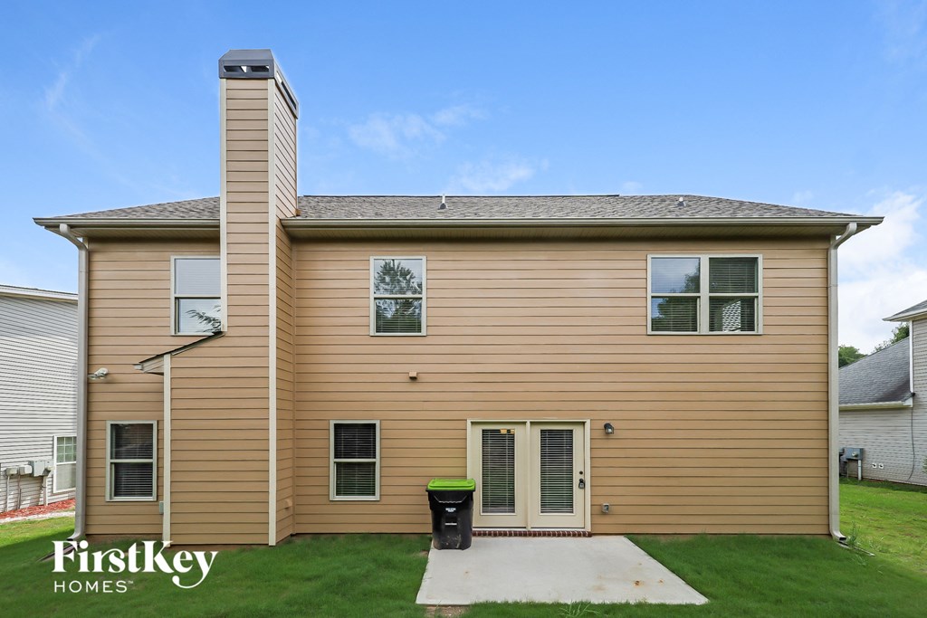 the front of a house with tan siding and green grass