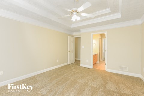 a living room with carpet and a ceiling fan