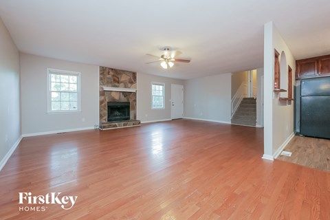 an empty living room with wood flooring and a fireplace