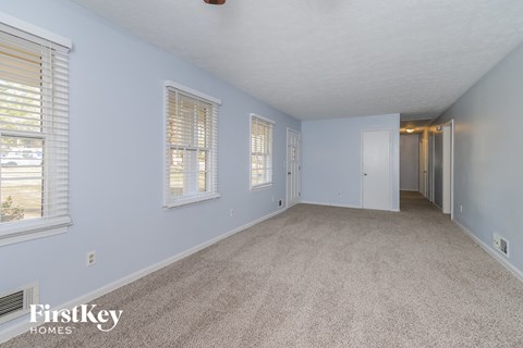 A spacious room with light blue walls and carpeted floor.