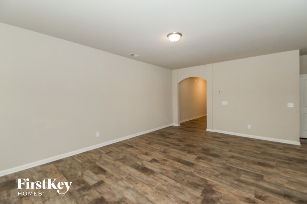 the upstairs living room with wood flooring and white walls