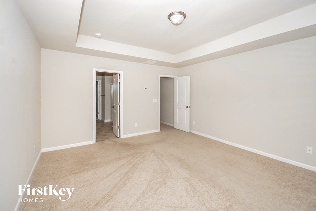 a spacious living room with carpet and white walls