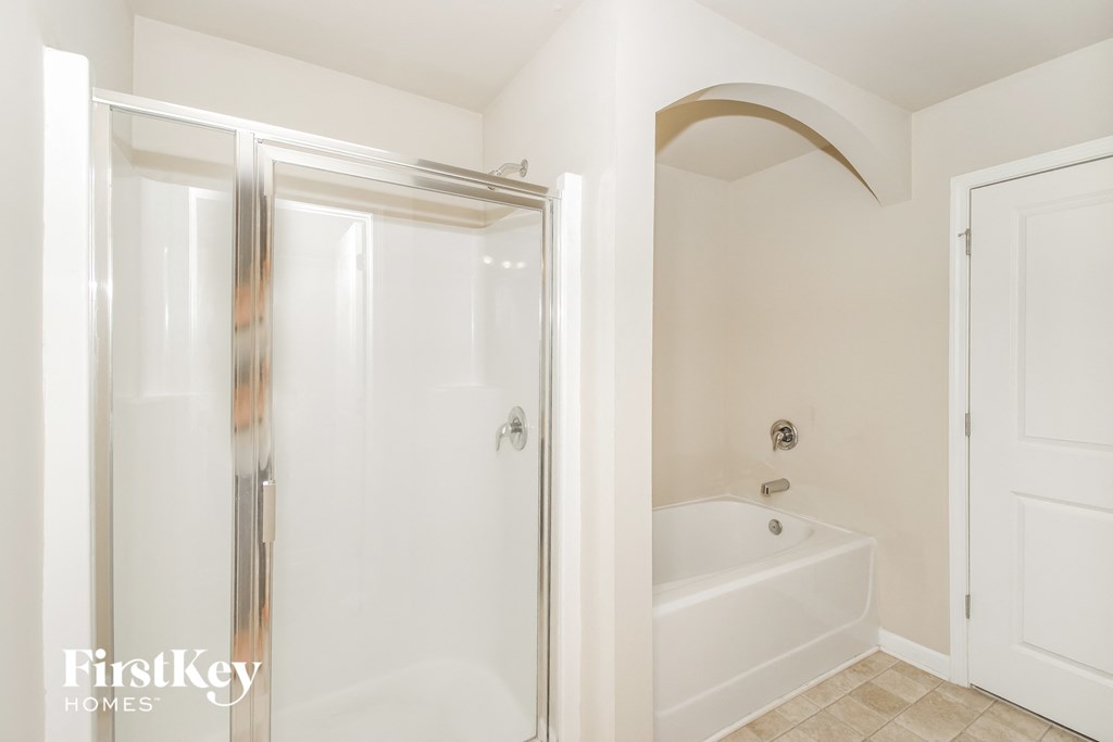 a bathroom with a shower and a bath tub and a closet