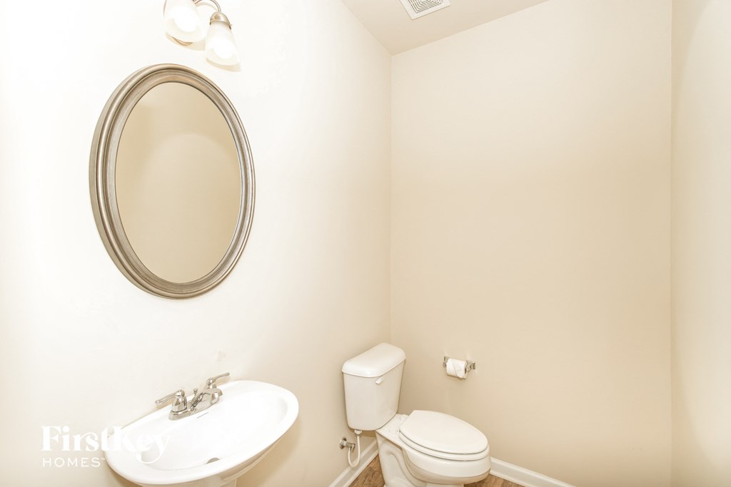 a bathroom with a sink toilet and a mirror