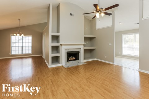 A spacious living room with a fireplace and built-in shelves.