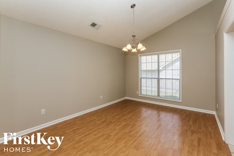 A room with wooden floors and a chandelier hanging from the ceiling.