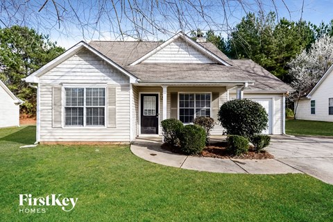 a white house with a sidewalk in front of it