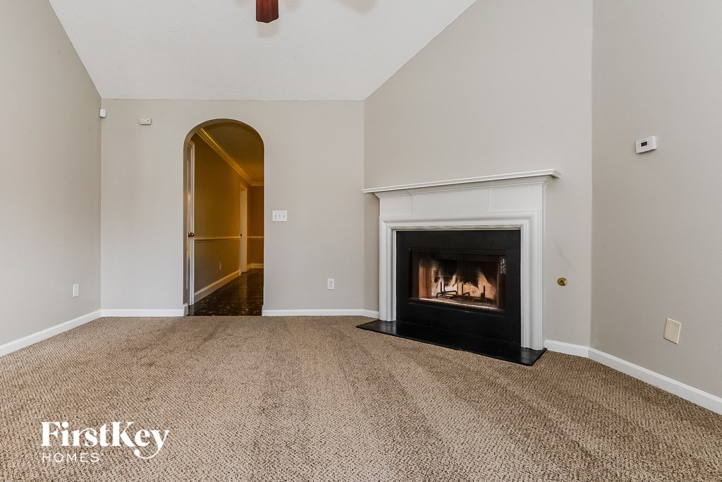 a living room with a fireplace and a door to a hallway