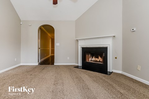 a living room with a fireplace and a door to a hallway