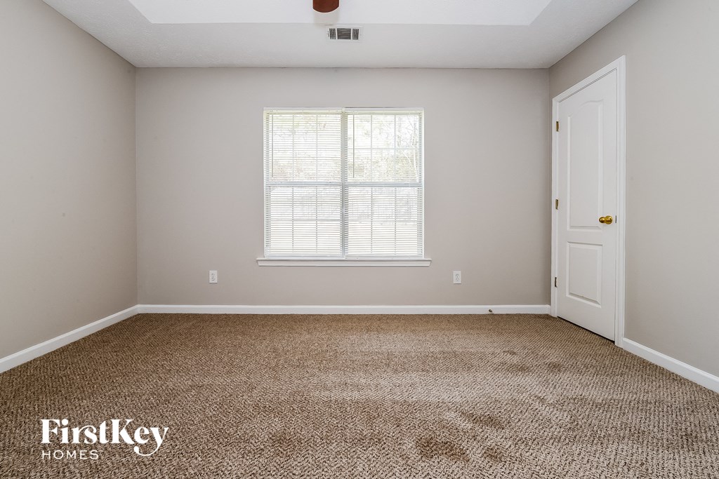 a bedroom with a carpeted floor and a window