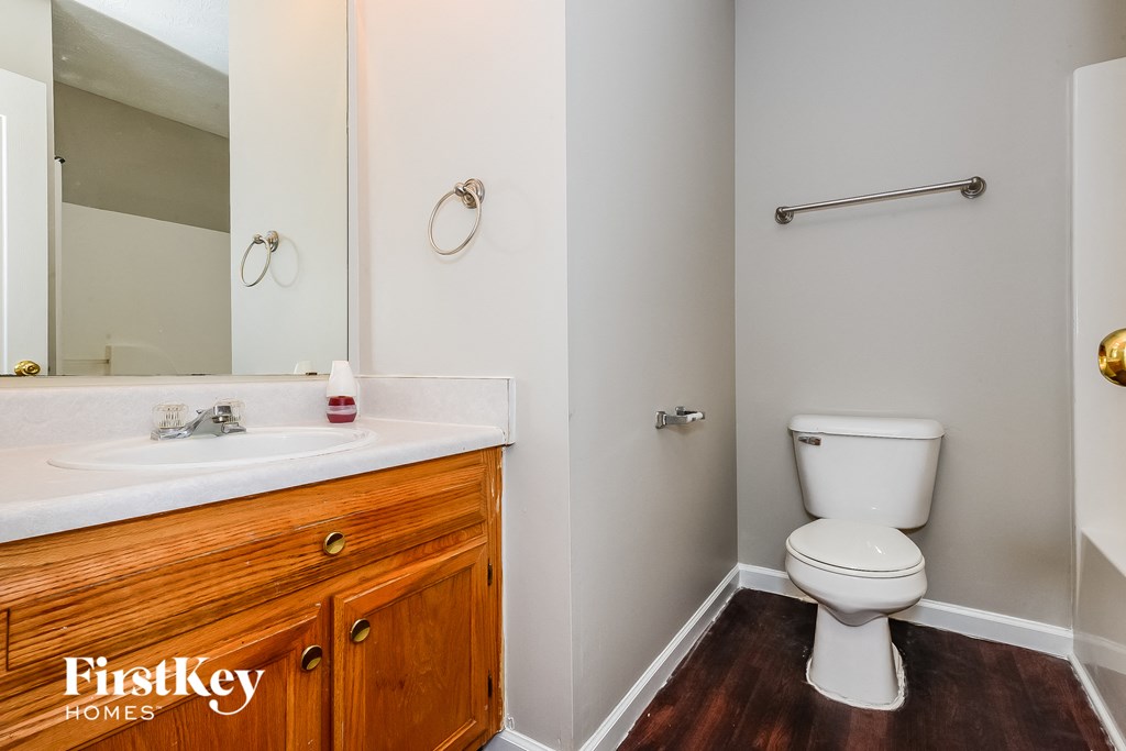 a bathroom with a toilet and a sink and a mirror
