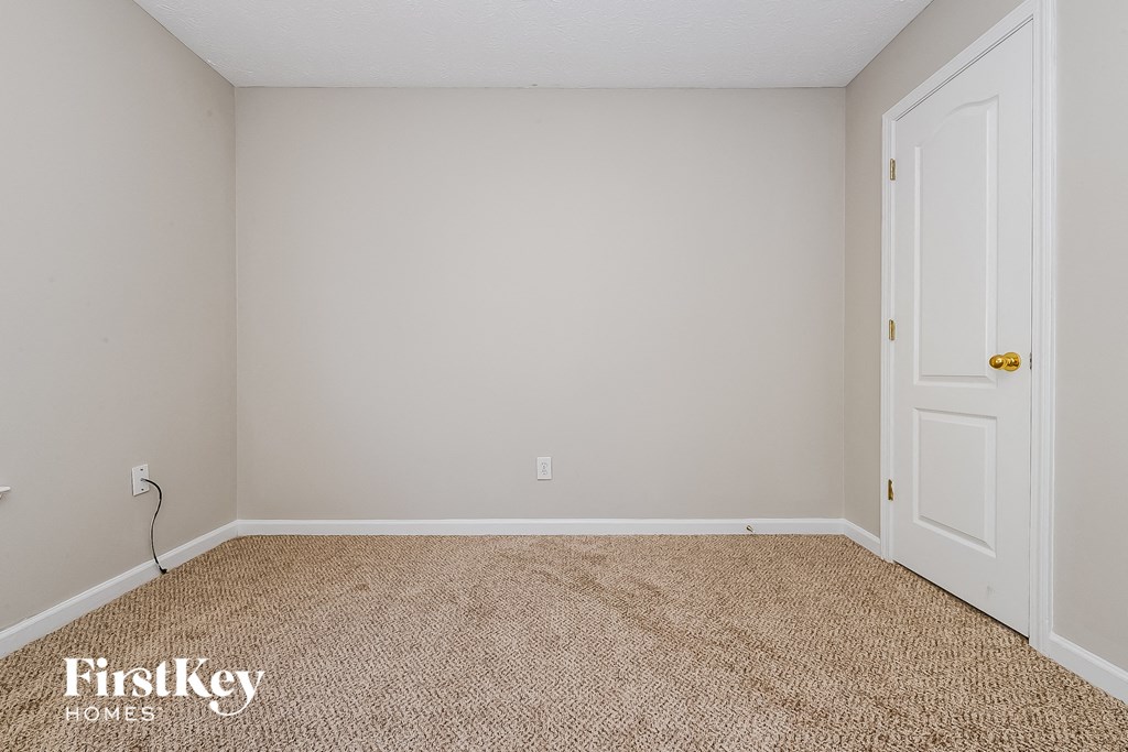 a bedroom with a carpeted floor and a white door