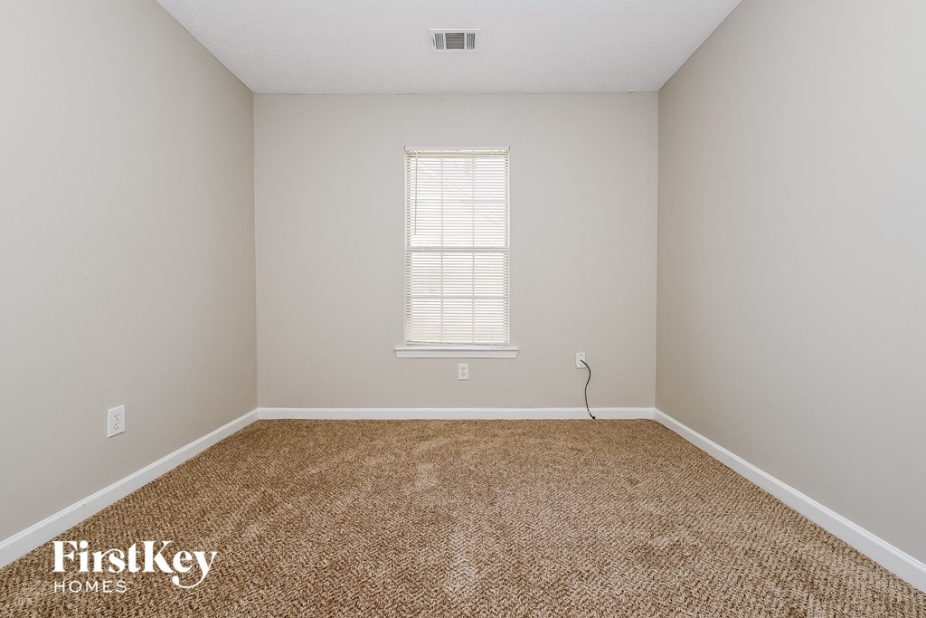 a bedroom with a carpeted floor and a window