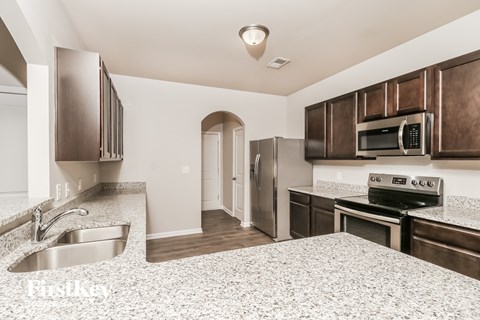 a kitchen with granite counter tops and stainless steel appliances