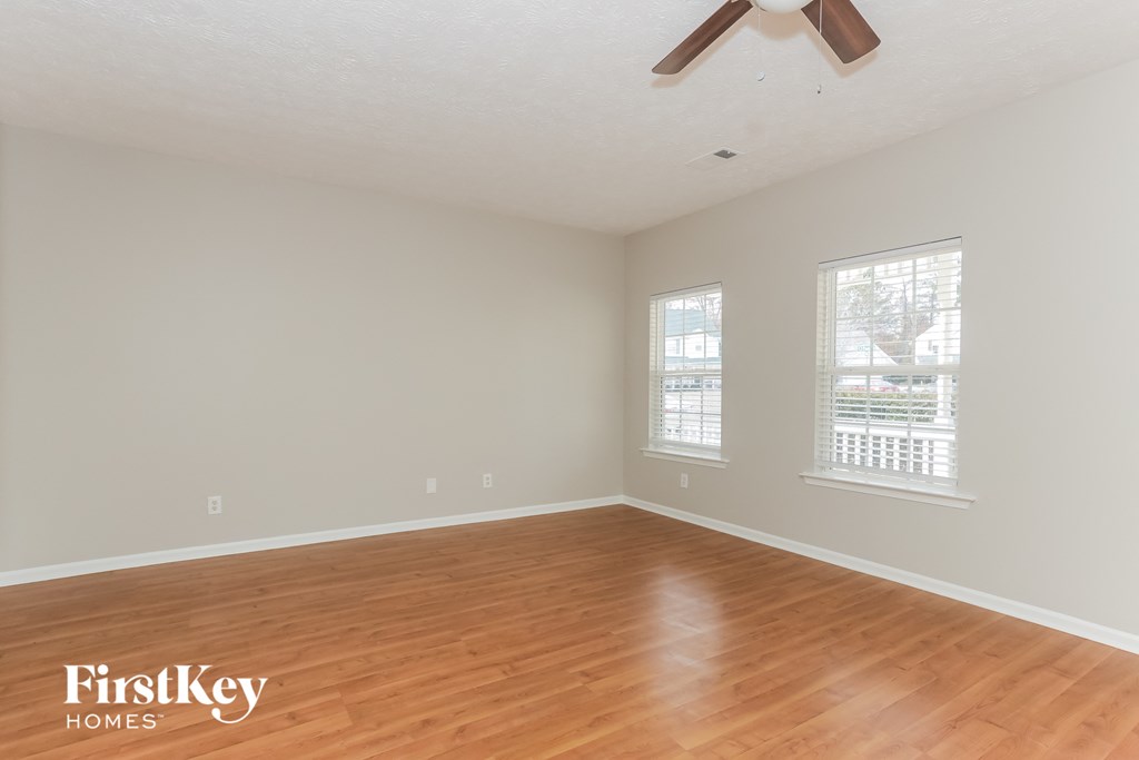 a living room with wood floors and a ceiling fan