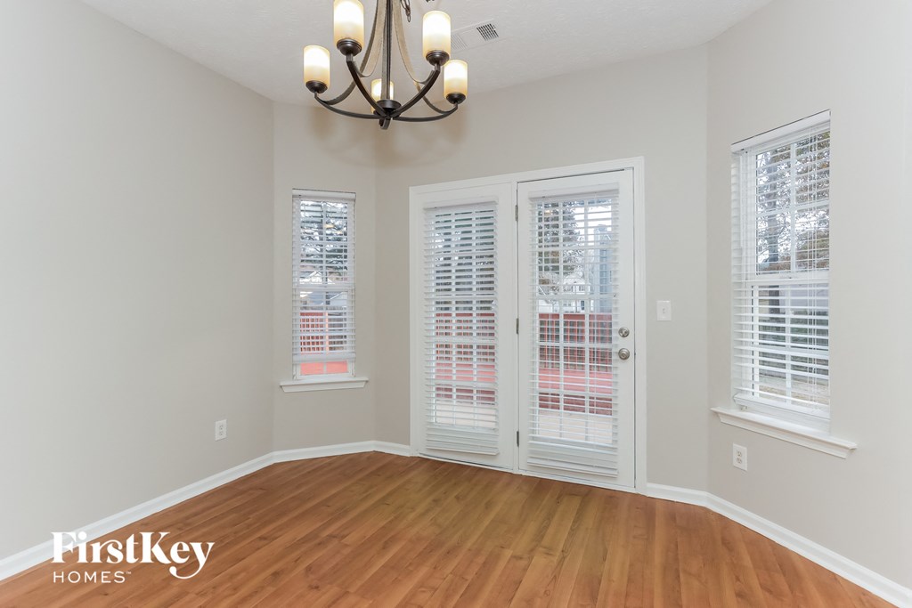 the living room of a home with a wood floor and a chandelier