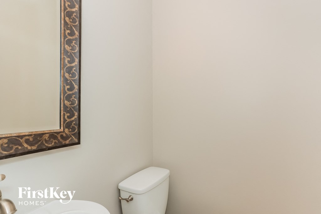a white bathroom with a white toilet and a mirror