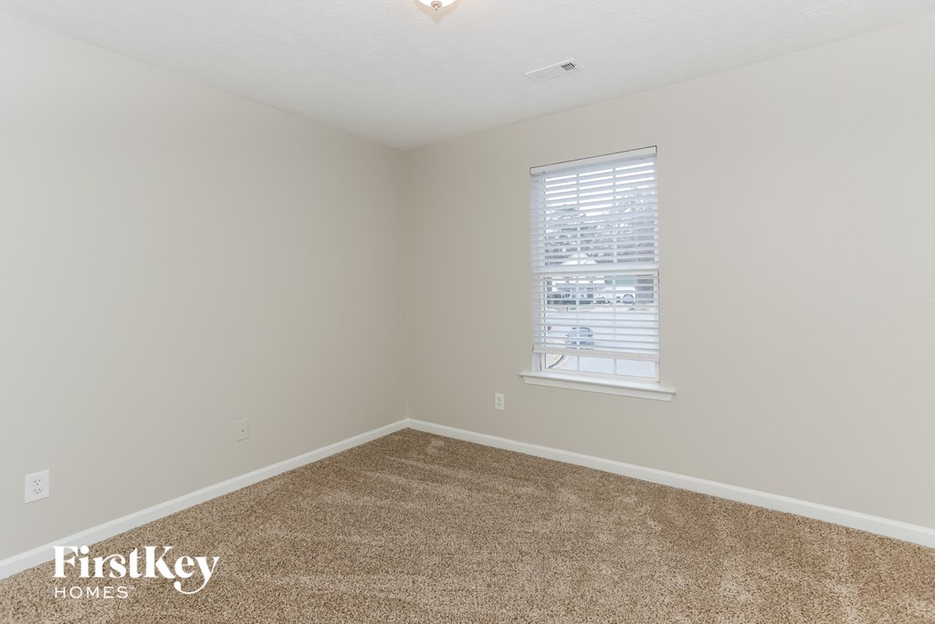 a bedroom with a carpeted floor and a window