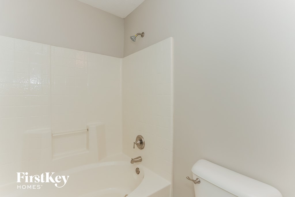 a white bathroom with a tub and a toilet