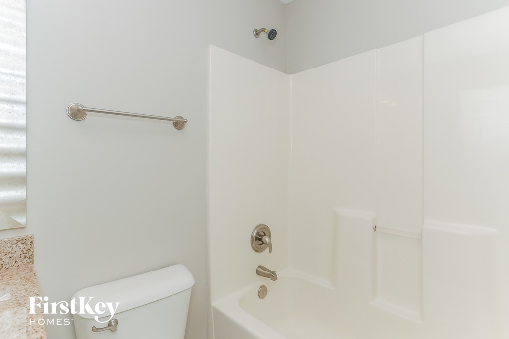 a white bathroom with a shower and a toilet