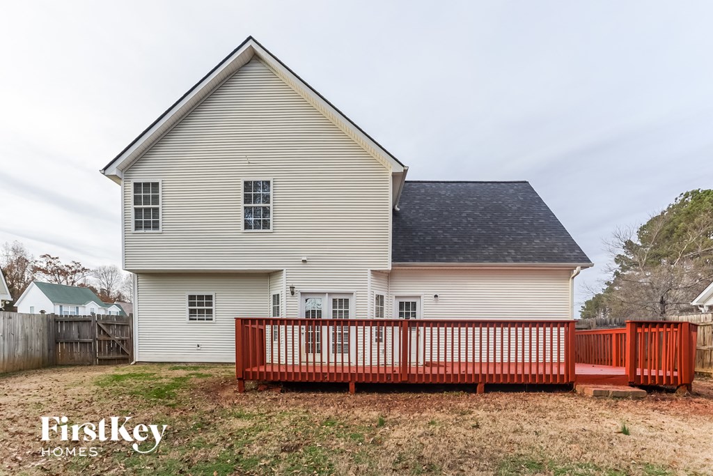 a white farmhouse with a wooden fence in front of it