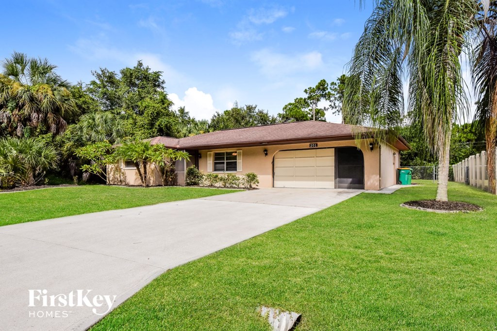 a yellow house with a driveway and a garage door