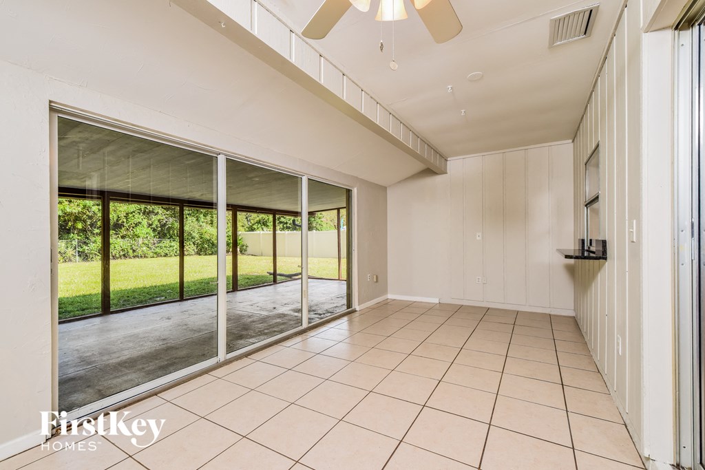 an empty living room with sliding glass doors to a patio