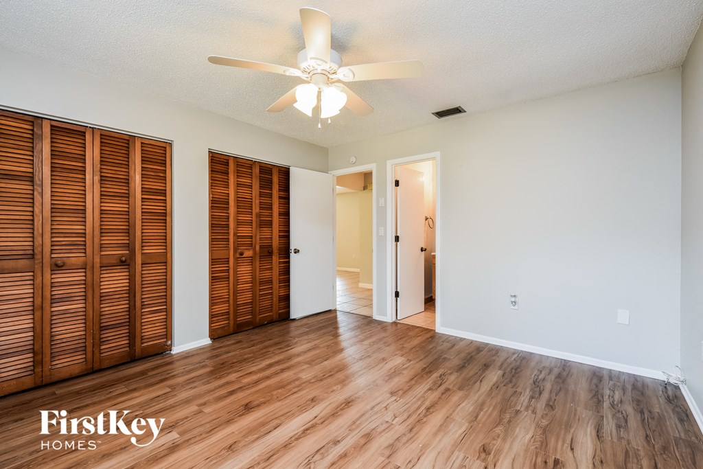 a living room with wood floors and a ceiling fan