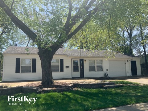 a white house with a tree in front of it