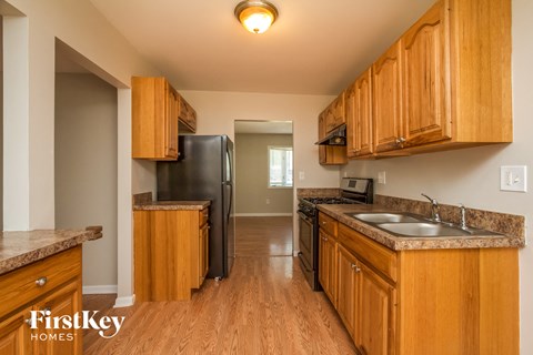 a kitchen with wooden cabinets and a black refrigerator