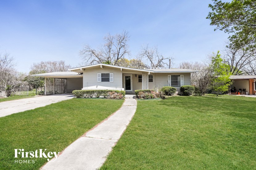 a white house with a lawn and a sidewalk
