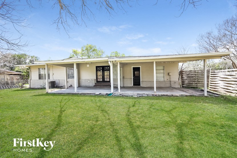 a small white house with a porch and a grassy yard