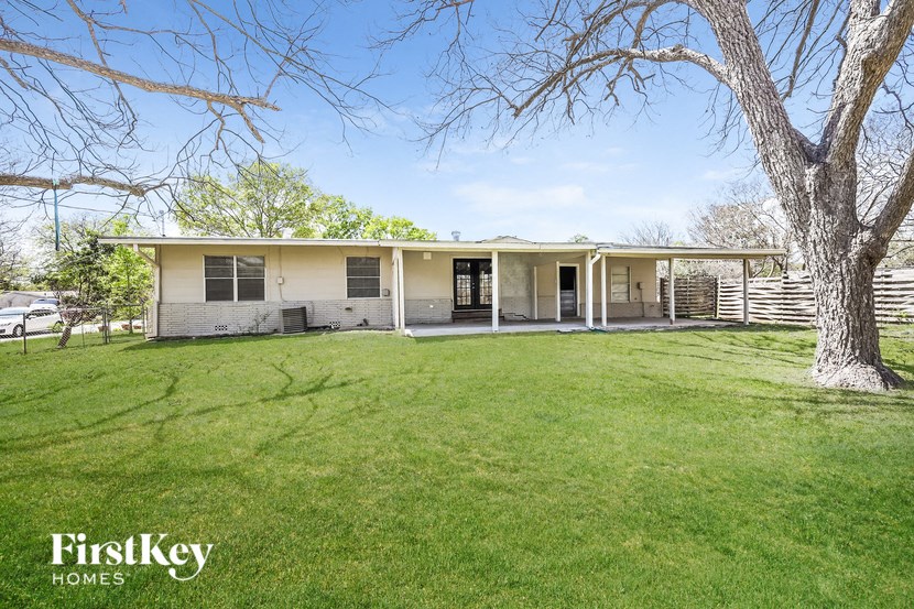 a white house with a yard and a tree