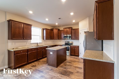 A kitchen with wooden cabinets and a refrigerator.