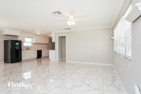 a kitchen with white cabinets and a black refrigerator