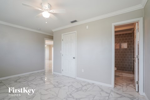 a renovated living room with marble flooring and a white door