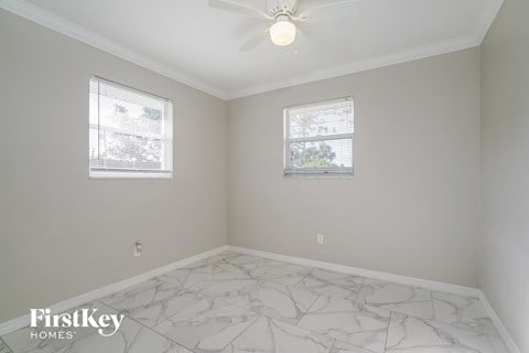 a bedroom with white marble floors and two windows
