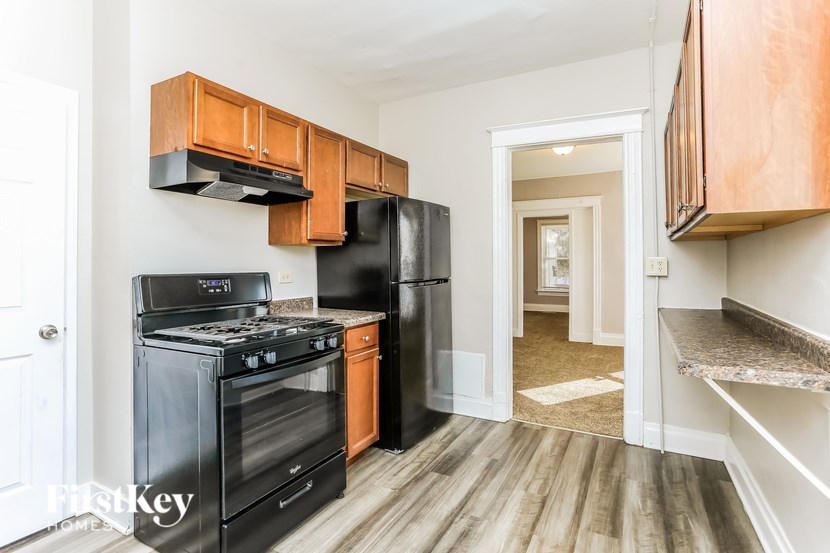 A kitchen with black appliances and wooden cabinets.