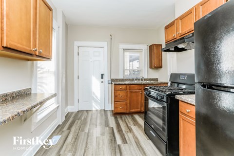 A kitchen with wooden cabinets and black appliances.