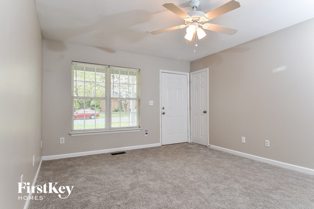 A room with a ceiling fan and two doors.