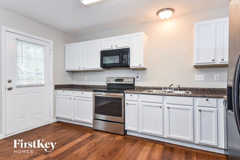 A kitchen with white cabinets and a stainless steel oven.