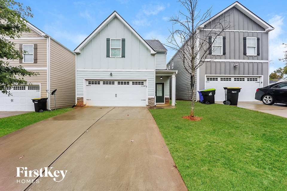 a white house with a white garage door and a driveway