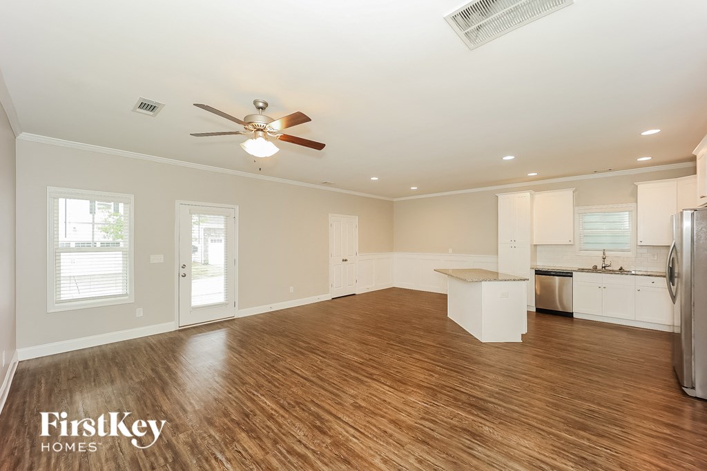 a kitchen and living room with wood flooring and a ceiling fan