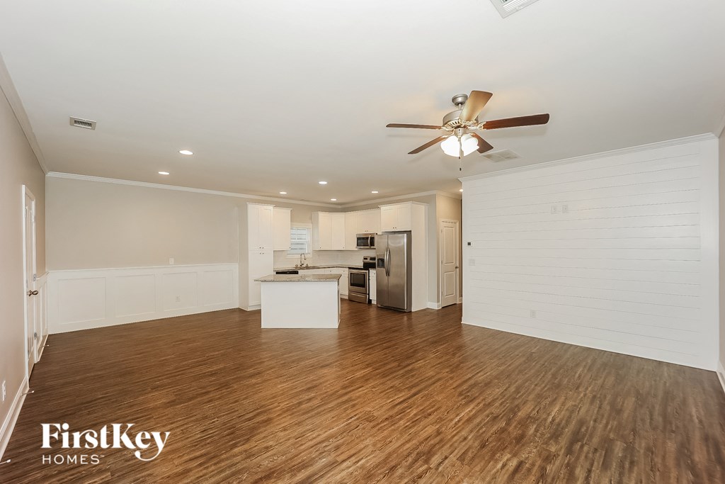 a living room with wood flooring and a ceiling fan
