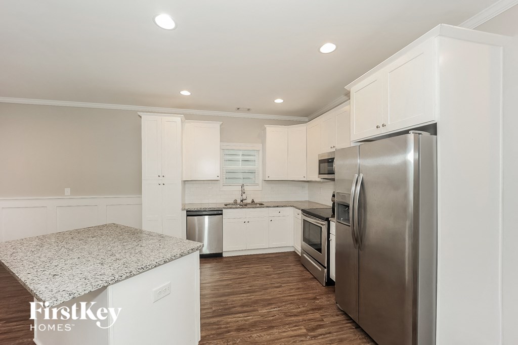 a white kitchen with stainless steel appliances and white cabinets