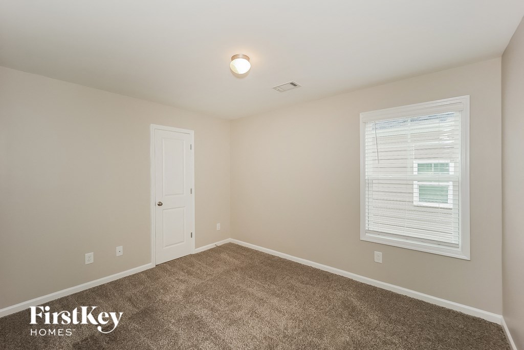 a bedroom with a carpeted floor and a white door