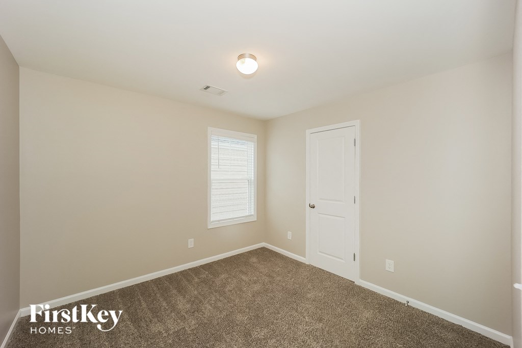 a bedroom with a carpeted floor and a white door