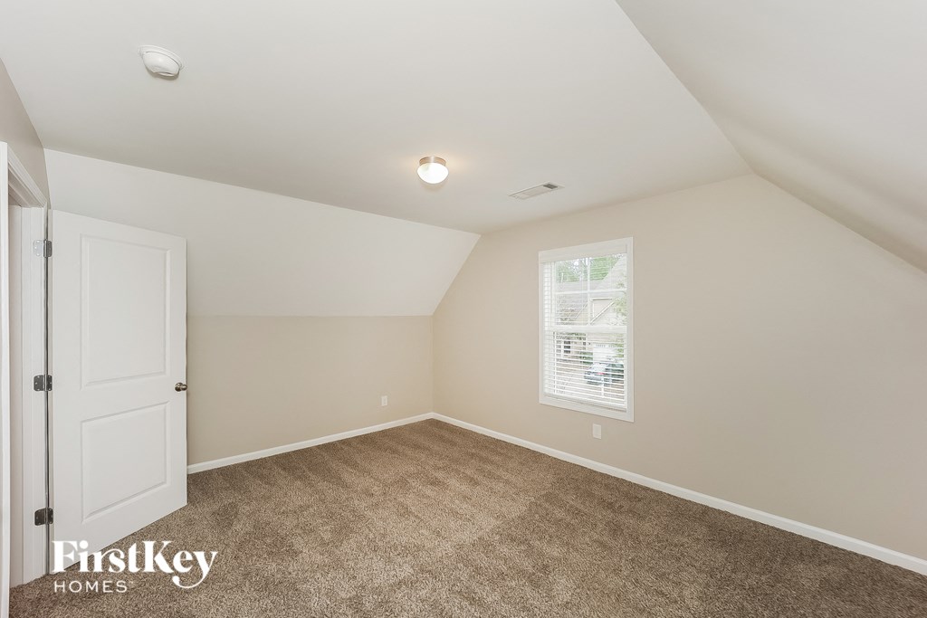 a bedroom with a carpeted floor and a white door